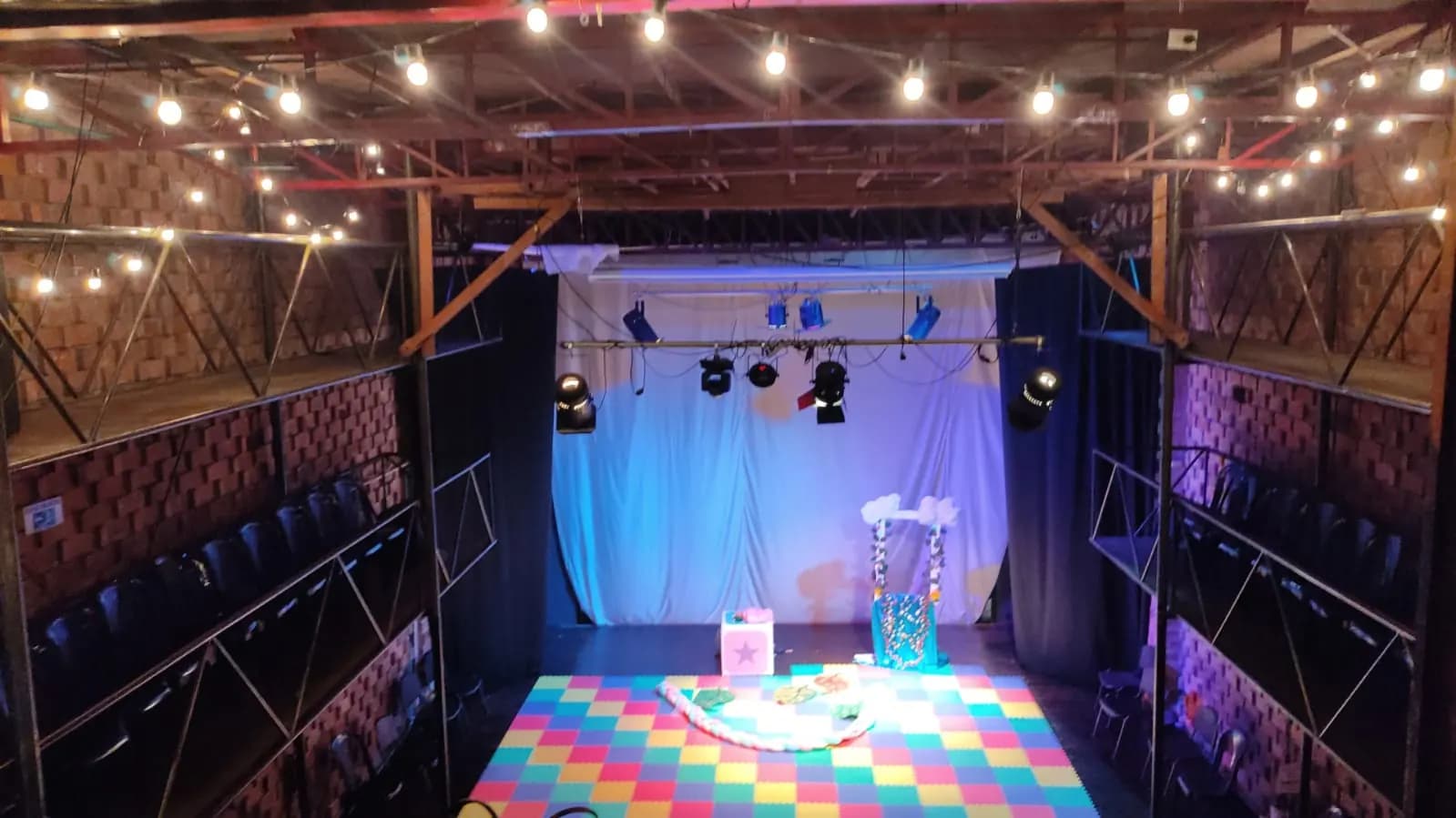 Escenario iluminado de Teatro La Mama preparado para una función